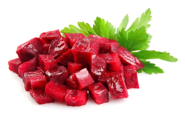 Segments of a beet with greens on a white background