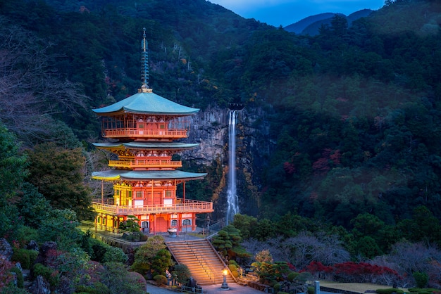 Пагода Seigantoji в виске святыни Kumano nachi taisha с водопадами Nachi вдоль в взгляде на сезоне осени известное и популярное туристское место на ноче в Wakayama, Японии.