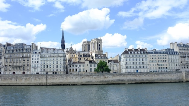 Seine river against notre dame de paris amidst buildings in city