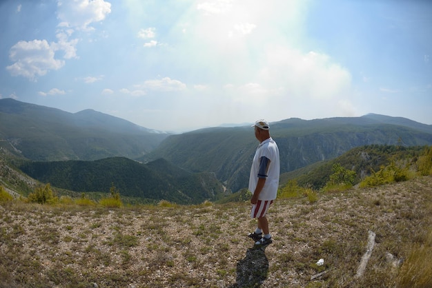 干上がった川床の峡谷で美しい夏の日にツアーを歩きながら、自然の中でリラックスするセイノールの男性ハイカー