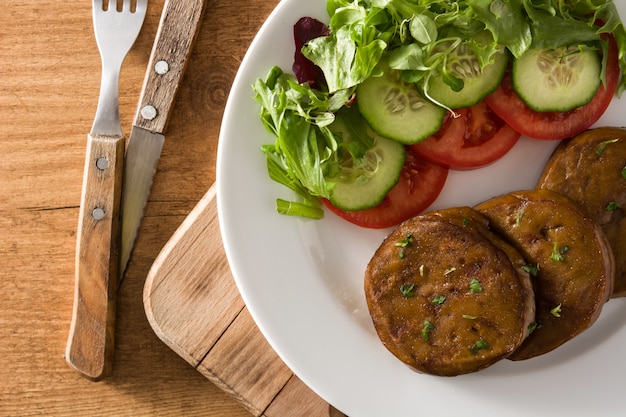 Seitan met groenten op houten tafelblad bekijken Nep vlees