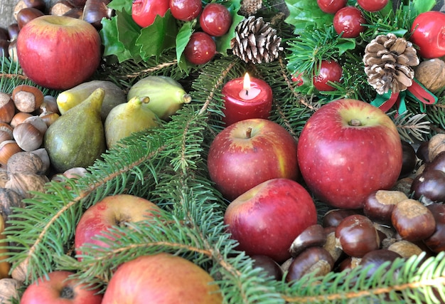 Seizoensfruit in Kerstdecoratie en kaarsen