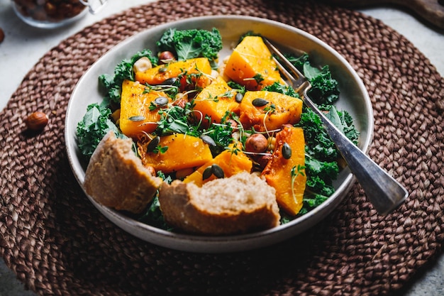 Seizoenssalade met gegrilde pompoen boerenkool kikkererwten pepita's en noten Herfst vegetarisch gezond recept