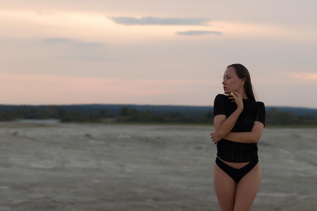 Seksuele vrouw in zwarte outfit op strand