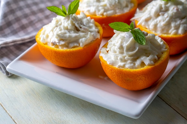 Selderijsalade met appel en walnoten geserveerd in oranje cups.