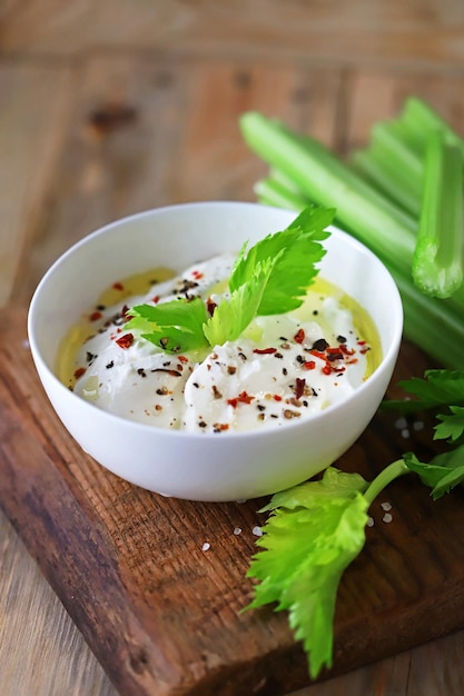 Selderijstengels met witte saus in een kom Gezonde voeding