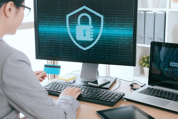 select focus photo of female office worker holding personal credit card using computer system setup information security locking with back view.