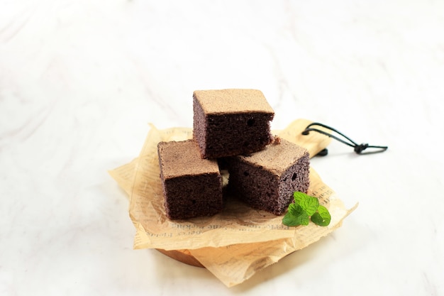 Selected Focus Black Glutinous Rice Chiffon Cake. Soft and Moist Sliced Cake, Made from a Black Sticky Rice Flour. Served on White Table. Copy Space for Text.