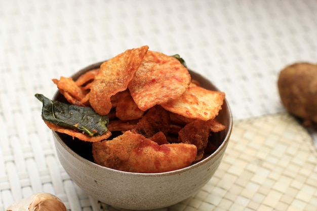 Selected Focus Homemade Kering Kentang Balado or Spicy Sweet Crispy Potato with Caramelized Spice. Using Lime Leaf for Aromatic Spice. Served on Grey Bowl, White Background