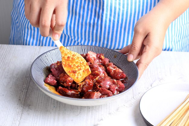 Избранный фокус Приготовление домашнего сатая из говядины (Сате Сапи Маранги) для меню Идул Адха. Сате Маранги - популярная уличная еда в Пурвакарте, Индонезия. Добавьте соевый соус к говядине