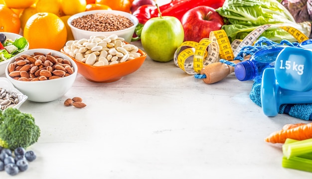 Selectie van gezond voedsel groenten fruit amandelen salade oefeningshulpmiddelen en meetlint