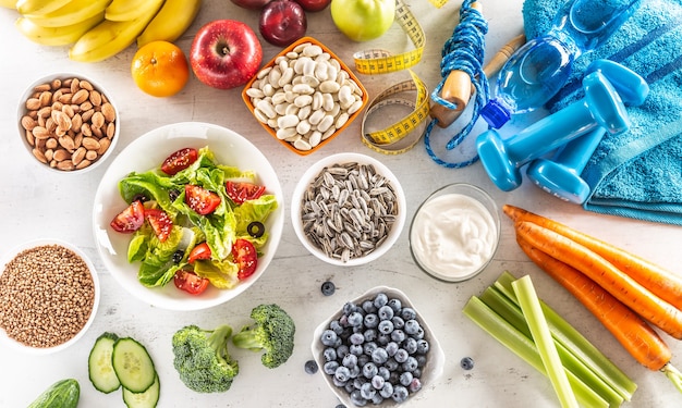 Selectie van gezond voedsel groenten fruit amandelen salade oefeningshulpmiddelen en meetlint