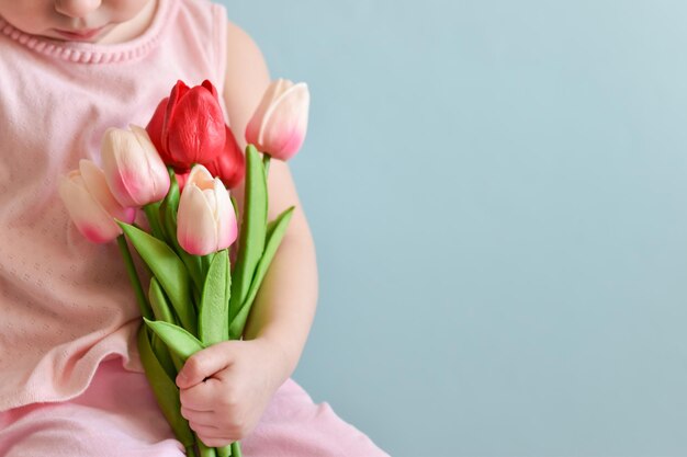 Selectieve aandacht Een boeket van mooie tulpen in de handen van een kind Het concept van Moederdag Vrouwendag kopieerruimte