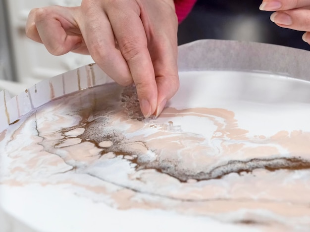 Selectieve aandacht Technologieproces voor het maken van een schilderij in stijl hars kunst vrouw werkt met glas steentjes en epoxy in studio maakt een houten standaard met de afbeelding Epoxyhars kunst schilderij