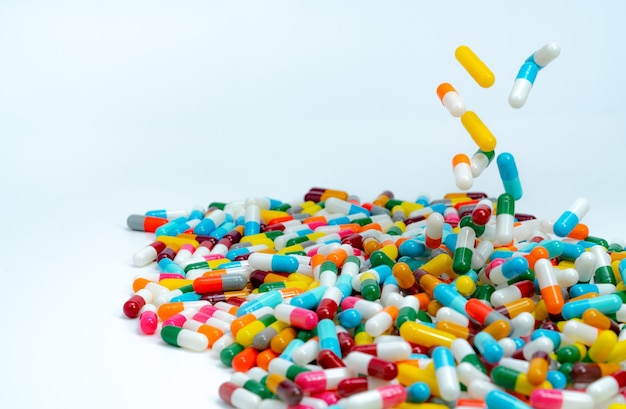 Selectieve aandacht voor stapel antibiotische capsule pillen. Kleurrijke antibiotica capsules pil vallen op witte tafel.