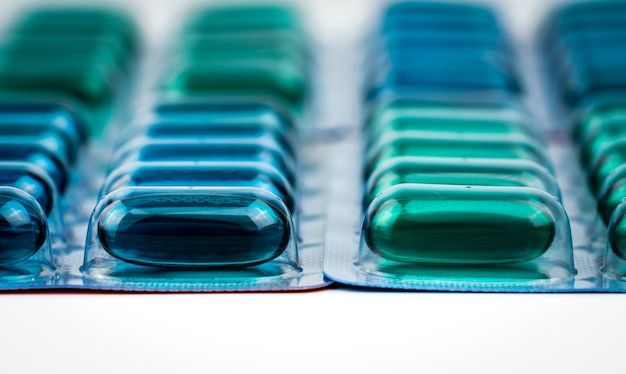 Selectieve focus op blauwe en groene zachte gelcapsulepillen in blisterverpakking