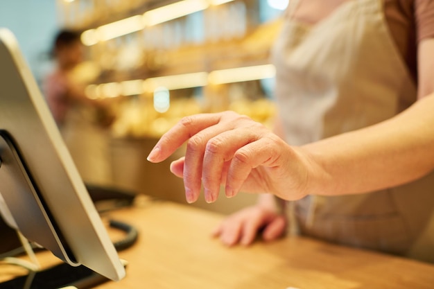 Selectieve focus op hand van volwassen vrouwelijke bediende die prijzen van producten invoert