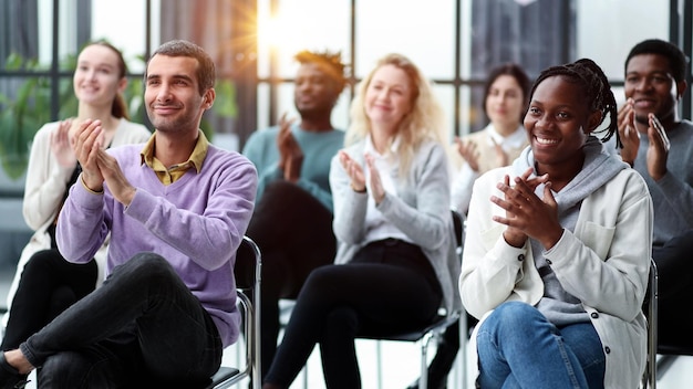 Selectieve focus van jonge zakenvrouw die samen met interraciale collega's applaudisseert tijdens semina