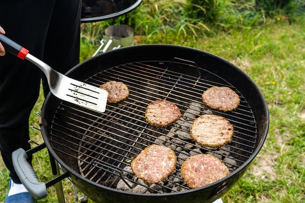 Selectieve focus van verse heerlijke hamburgerkoteletten die op bbq-grill grillen