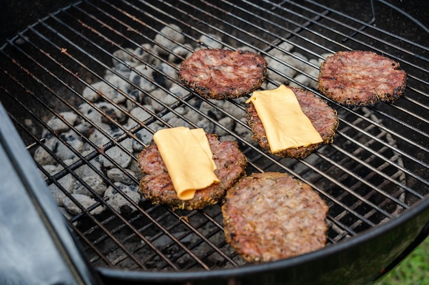 Selectieve focus van verse heerlijke hamburgerkoteletten met kaas grillen op bbq-grill