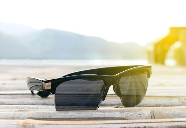 Selectieve focuszonnebril op bamboevloer met burst-zonsopganglicht, droomzachte stijl