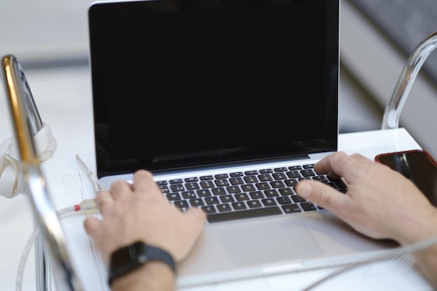 Selectieve scherpstelling van een man die aan een laptop werkt