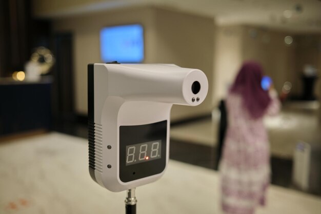 Foto selectieve scherpstelling van een staande digitale temperatuurscanner in het hotel