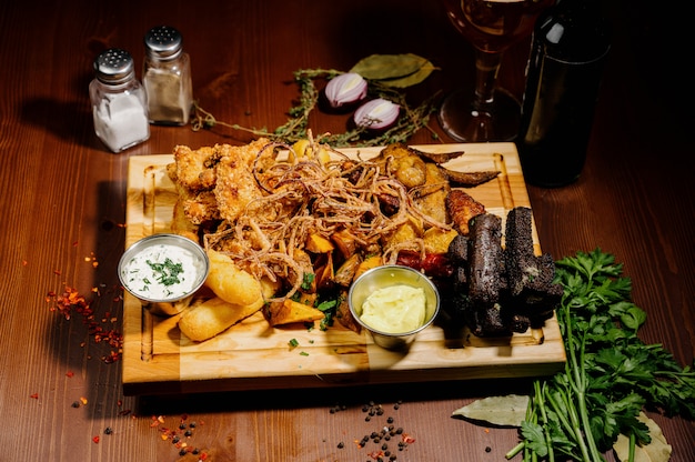 Selection of beer and snacks. Chips, fish, beer sausages on the table