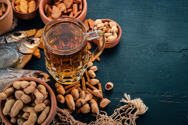 A selection of beer and snacks Light beer dark beer live beer On a black wooden background Free space for text Top view