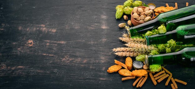 A selection of beer and snacks Light beer dark beer live beer On a black wooden background Free space for text Top view