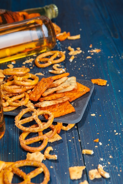 A selection of beer and snacks on wooden surface 