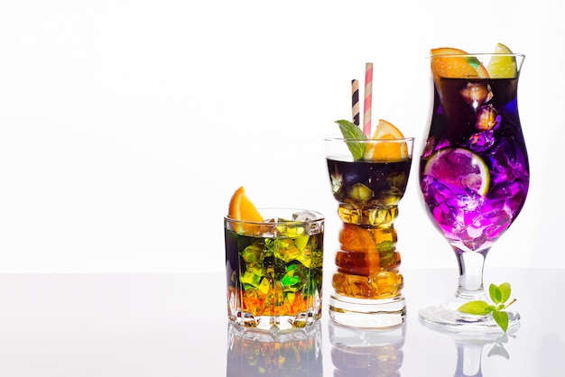 Selection of colorful festive drinks, alcoholic beverages and cocktails in elegant glasses on white