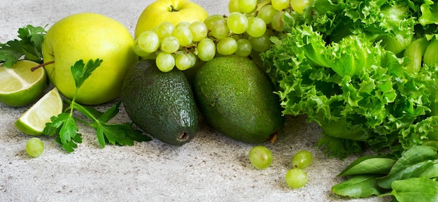 灰色のコンクリートの背景のクローズアップの緑の野菜や果物の選択。デトックス、ダイエット、ベジタリアン、フィットネス、健康的なライフスタイルのコンセプト。