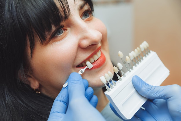 사진 치과에서 전문적인 미용 미백을 위한 올바른 치아 색상 선택 의사는 환자의 치아를 선택합니다