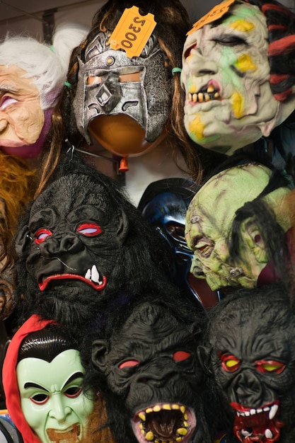 Photo selection of theatrical spooky masks on display in fancy store of trick different rubber head of monsters mask for hallows eve party at horror store