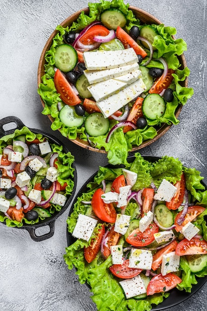 Selection of traditional Greek salad in a bowls. White background. Top view.