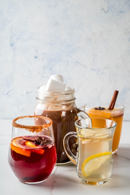 Photo selection of various autumn traditional drinks: hot chocolate with marshmallow, tea with lemon and ginger