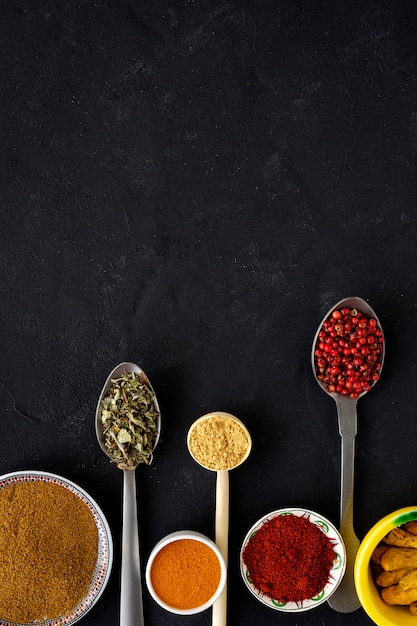 Selection of various species and herbs in bowl and spoons