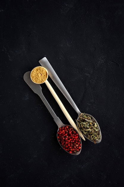 Selection of various species and herbs in bowl and spoons