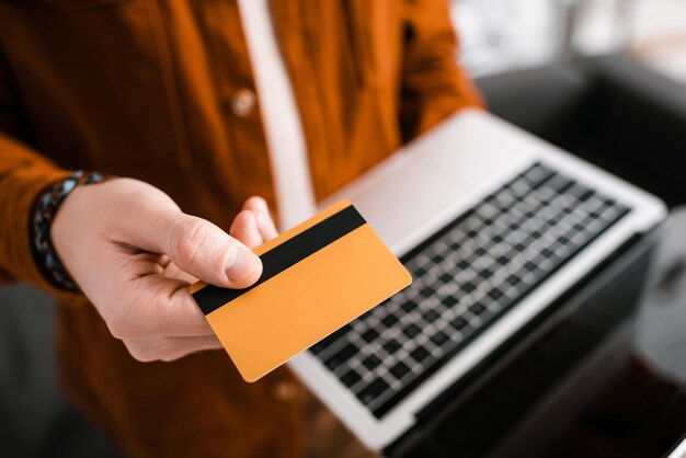 Selective focus of 3d artist holding credit card and laptop with blank screen