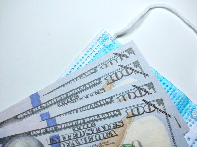 Selective focus of a banknote with face mask on a white backgroundCrisis and economic conceptShot were noise and grain