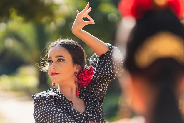 Foto messa a fuoco selettiva su una donna ispanica di bellezza che balla il flamenco di fronte a un'altra donna in un parco