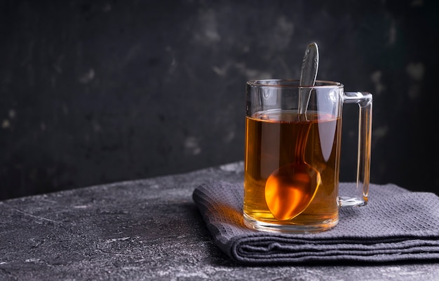 Selective focus: Ceylon black tea in a transparent mug on a table. copyspace. horizontal position. minimalistic style