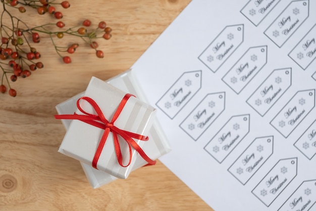 Selective focus of Christmas gift with red ribbon on wooden table, with copy space.