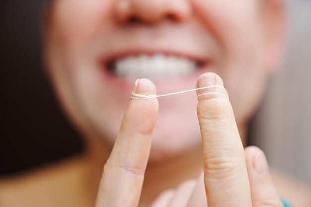 Selective focus closeup a man brush your teeth with dental floss