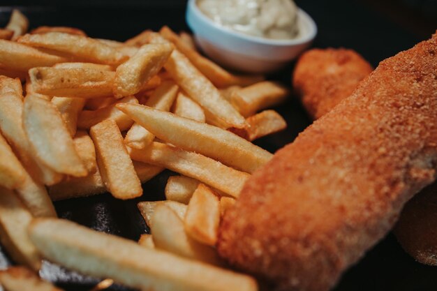 Selective focus closeup of potato fries nuggets and mayonnaise on a platter