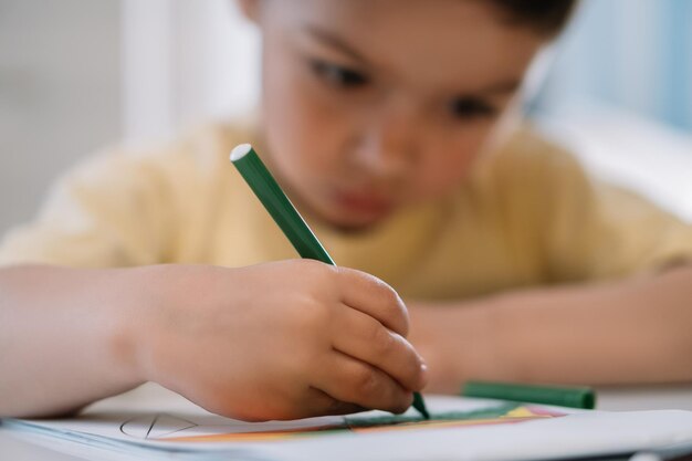 Selective focus of cute attentive child drawing with feltip pen