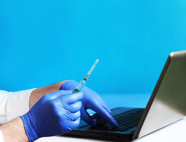 Selective focus on doctor hand wearing rubber glove and holding medical syringe needle