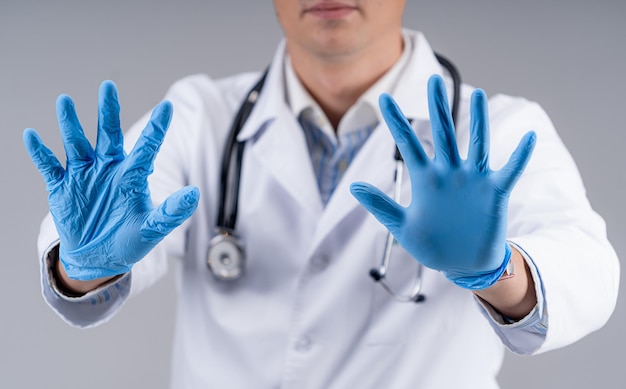 Selective focus on doctor`s hands in blue medical gloves. cropped photo of a medic in scrubs. healthcare concept.