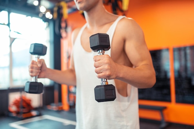 Selective focus of a dumbbell in male hands